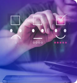 Mão tocando uma tela com três emojis – uma cara triste, uma neutra e outra feliz.