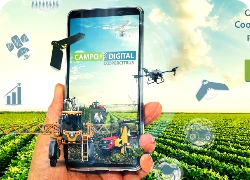 Mão segurando um celular e diversos equipamentos agrícolas e drones em volta.